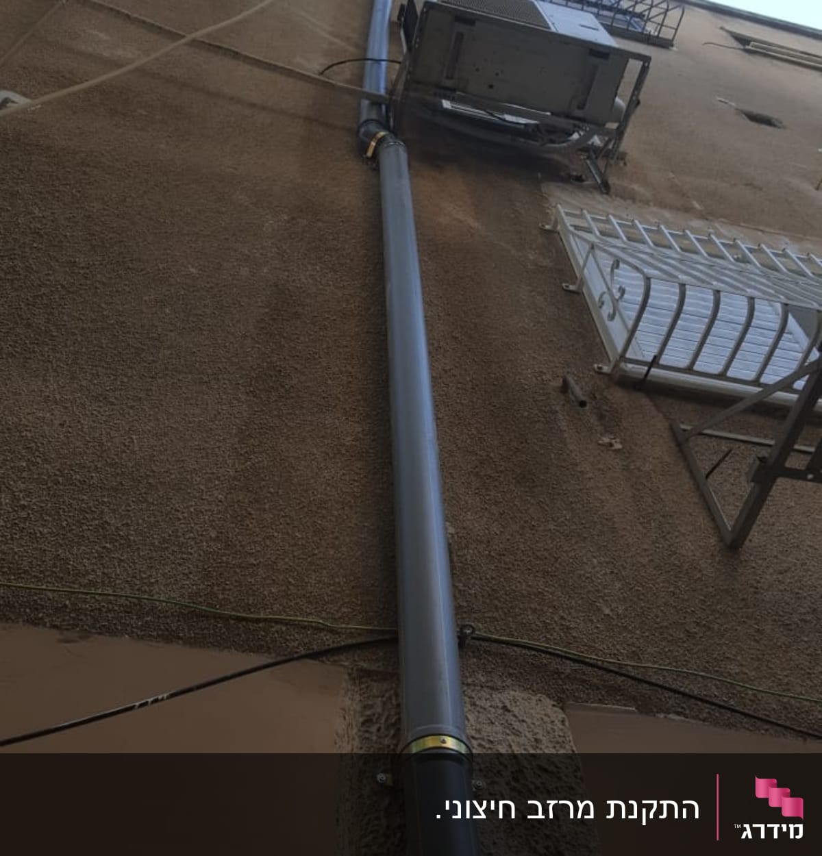 צינור מתכת מחובר לקיר בניין